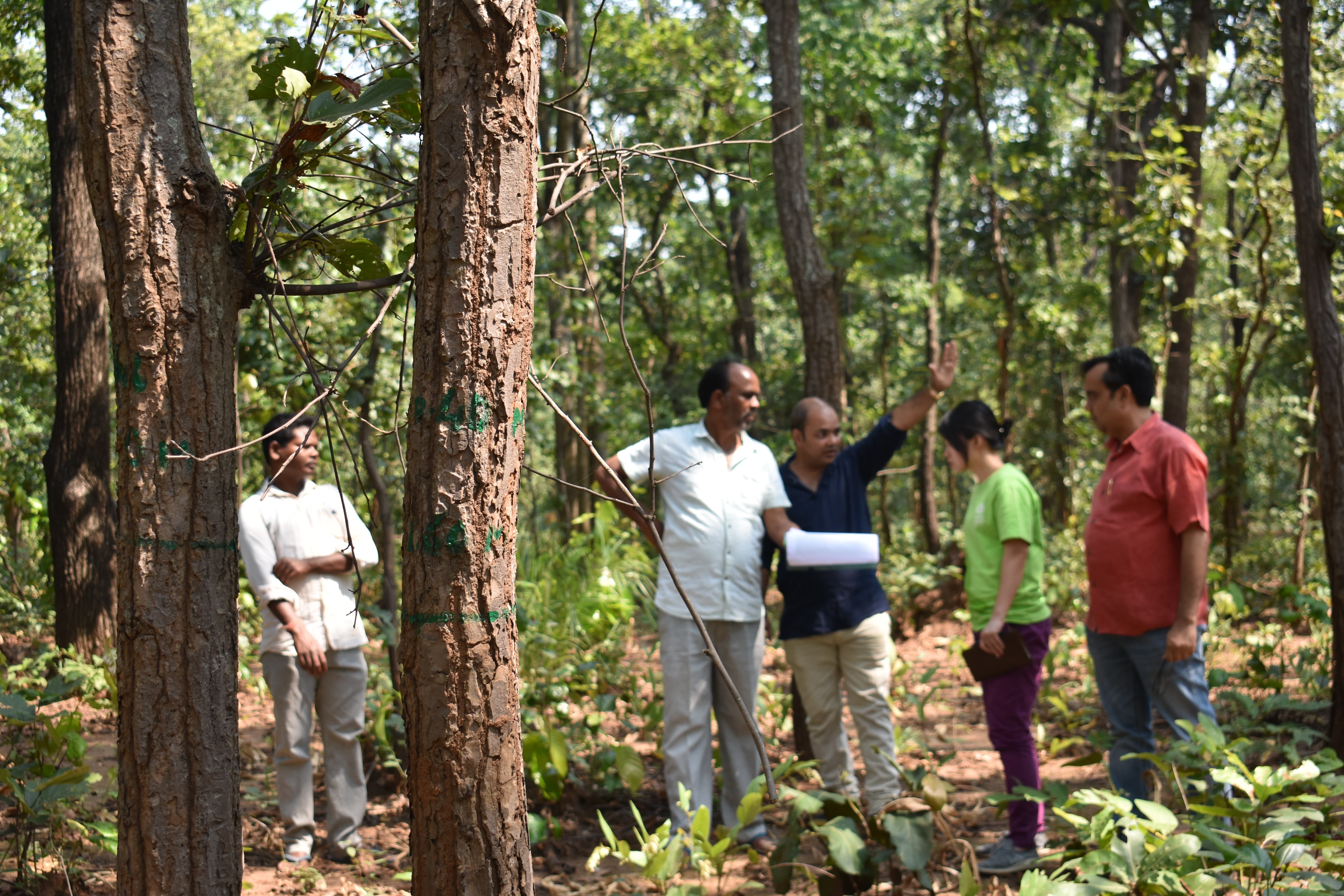 Oxfam staff and partner teaching tribal people using GPS